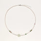 Delicate pearl necklace with pale green serpentine jade centerpiece and colorful agate beads on cream background
